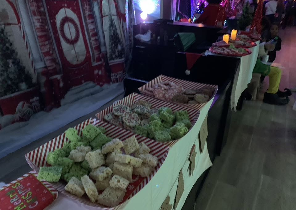 A dessert table with Christmas treats, cookies, and rice krispie treats.