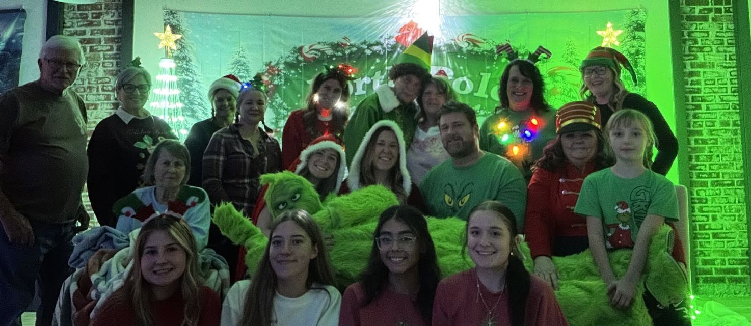 A large group of family and volunteers in Christmas costumes at LLC North Pole Christmas.