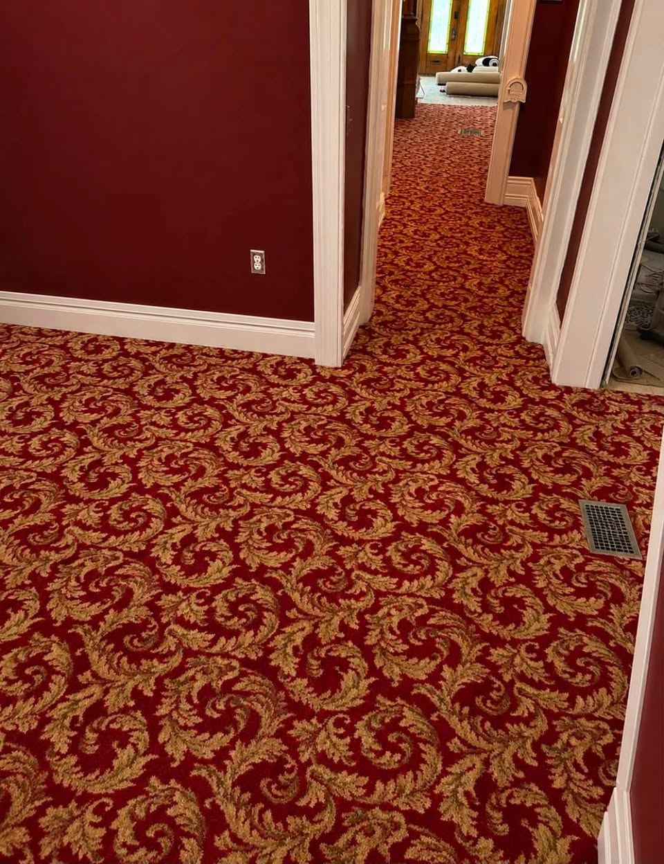 Ornate red and gold patterned carpet in the hallway of a historic home in downtown Louisville.