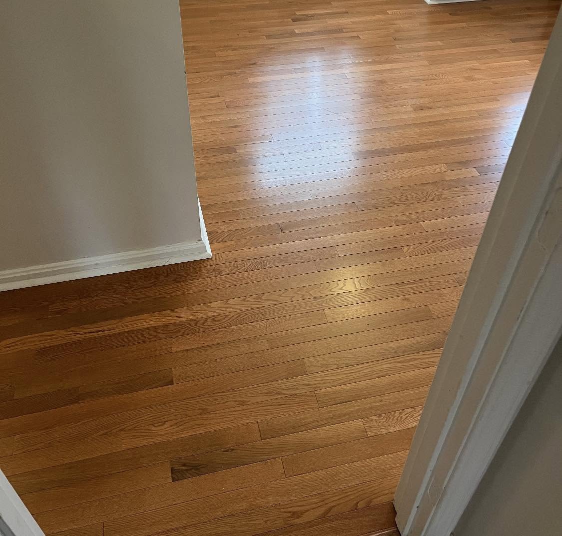 Glossy natural oak hardwood flooring in a hallway.