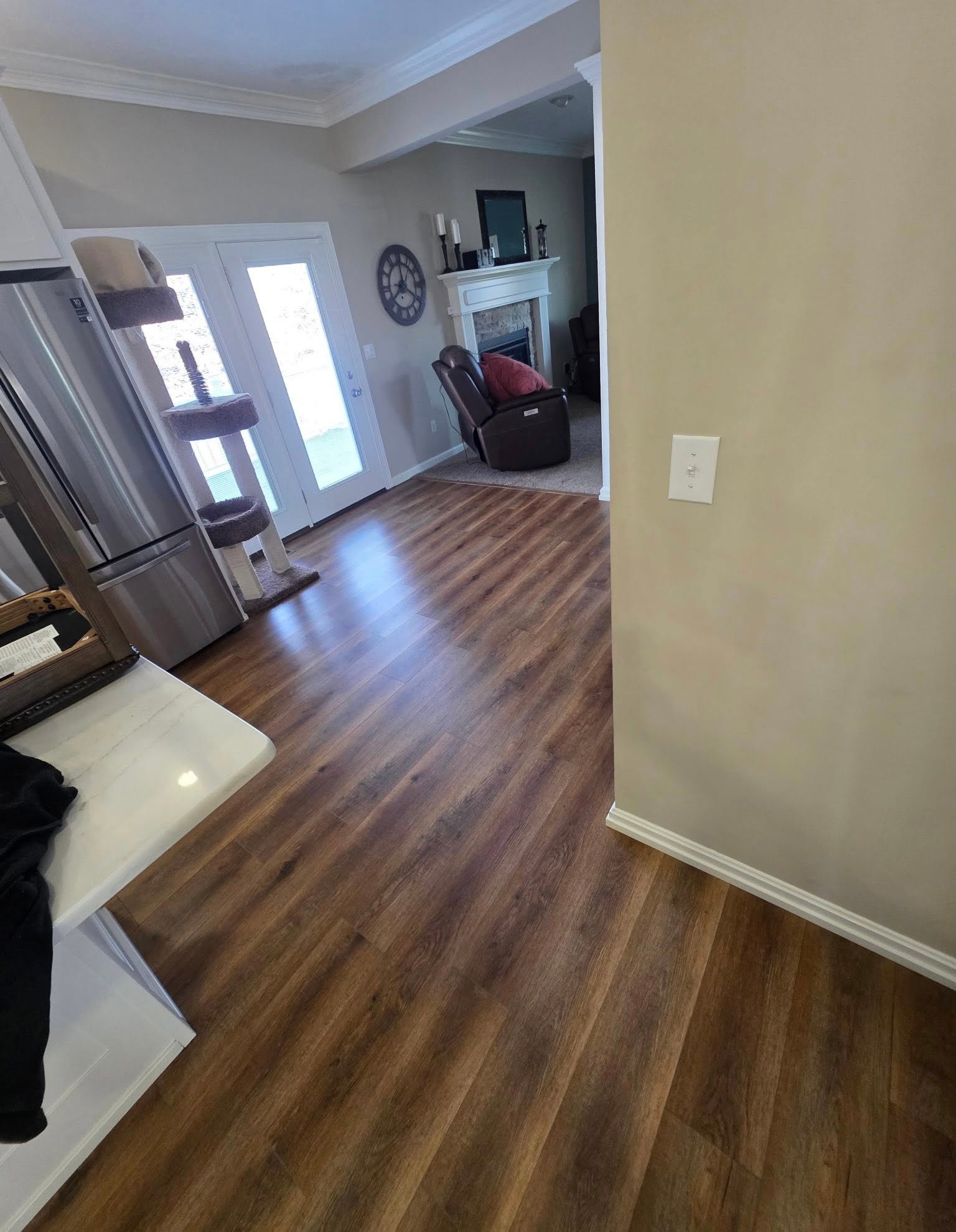 AeroCore flooring in the color Illusion Oak, in a kitchen and living room with a stone fireplace.