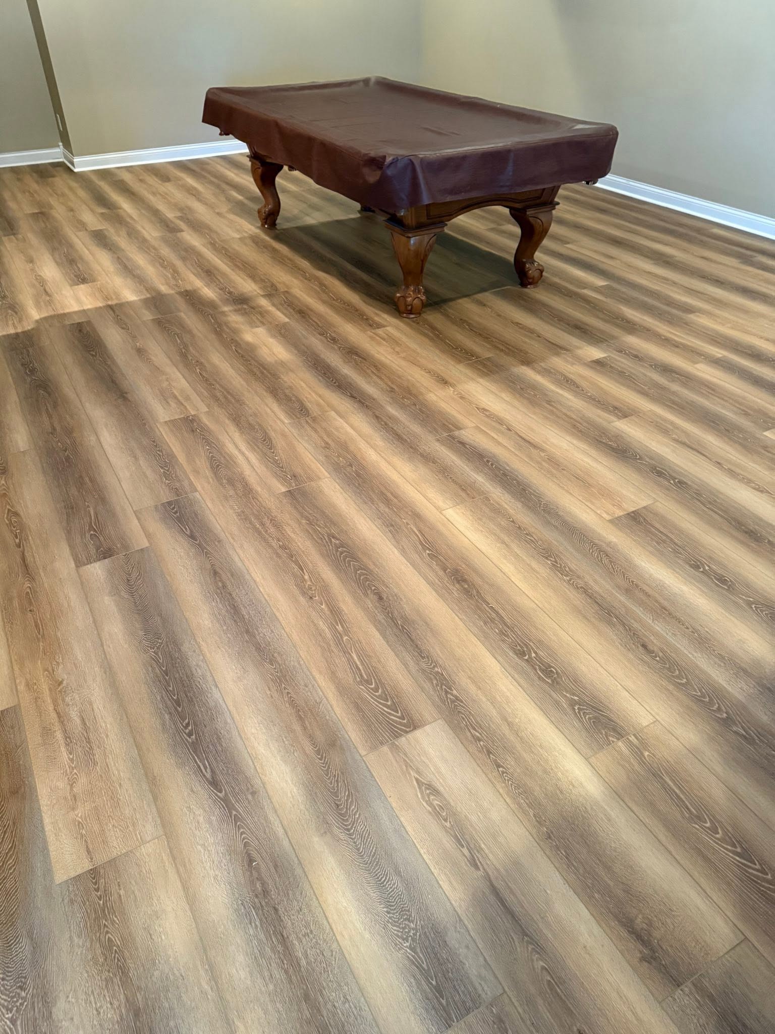 Audacity Symphony flooring in the color Tyler, in a game room with a pool table.