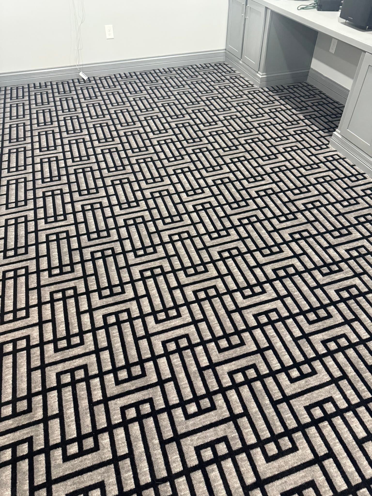 Black-and-white geometric carpet in a home office.