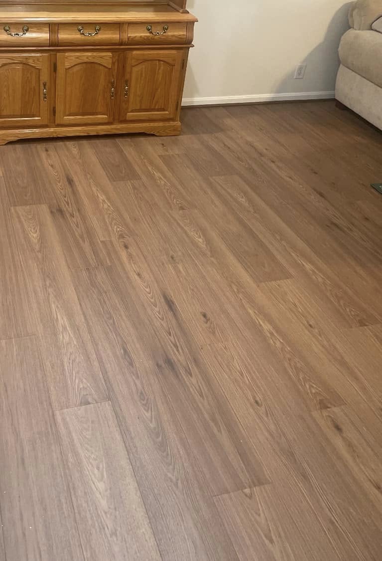 Medium-brown hardwood flooring in a living room next to an oak hutch.