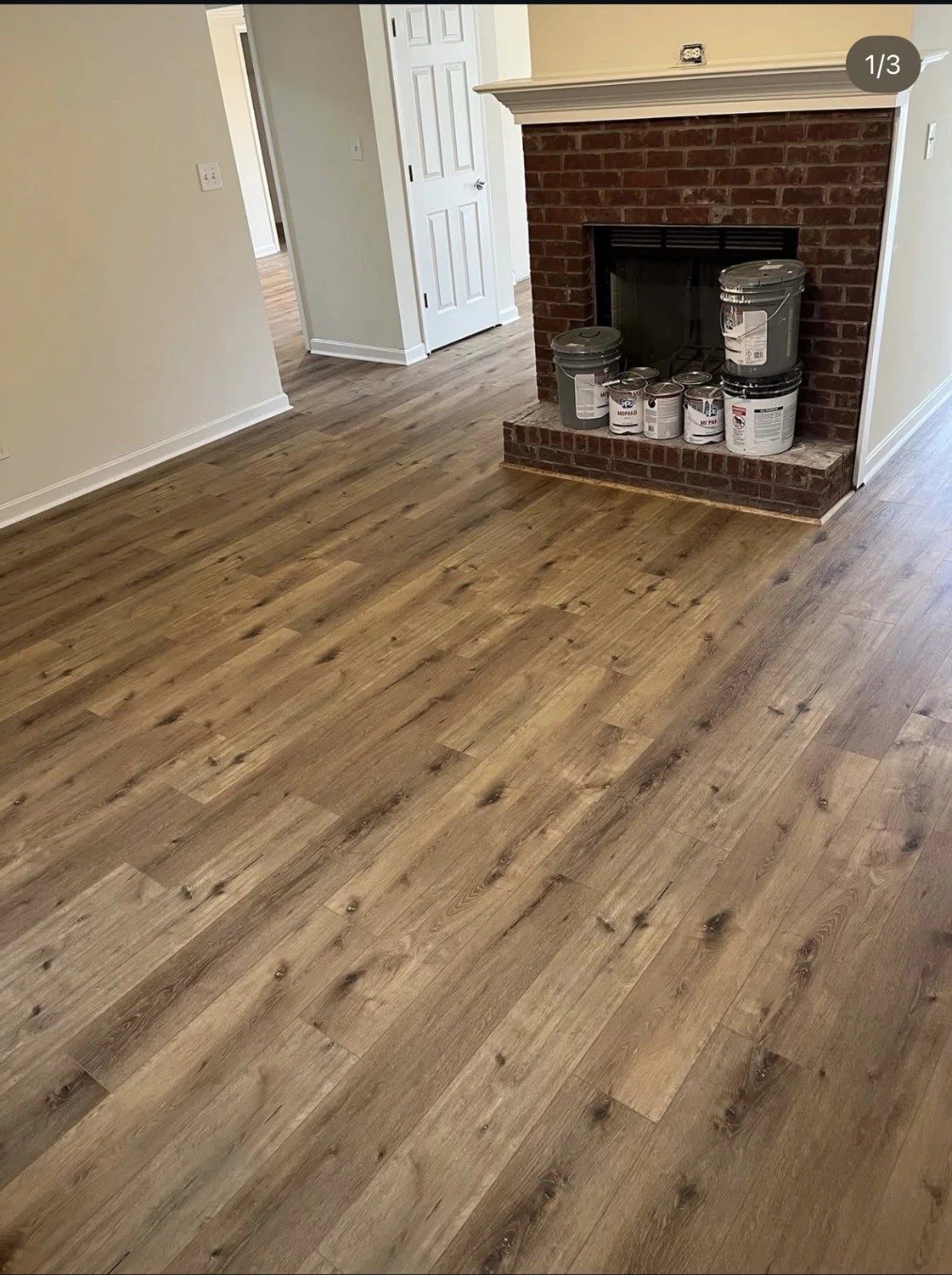 AeroCore flooring in the color Illusion, in a living room with a brick fireplace.