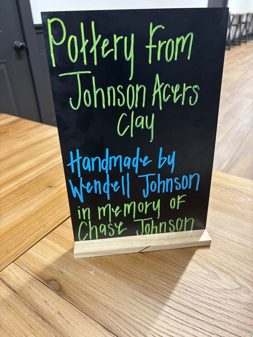 Chalkboard sign reading Pottery from Johnson Acres Clay, handmade by Wendell Johnson in memory of Chase Johnson.