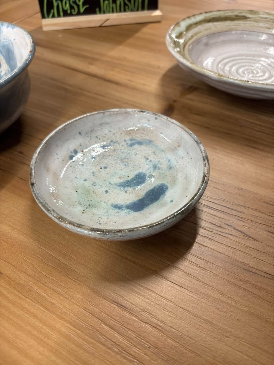 A small handmade pottery dish with blue and green glaze.